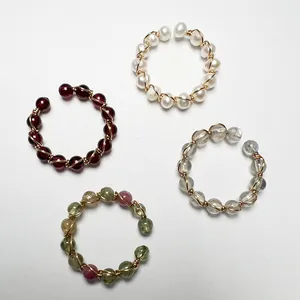 Dettaglio di anelli fatti a mano in filo d'oro 14K con pietre preziose naturali