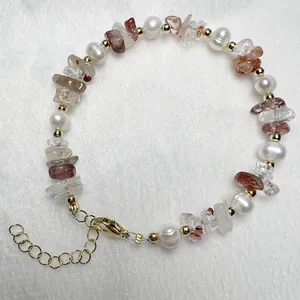 Detail van zoetwaterparel armband met rode kristalstenen en goudkleurige karabijnsluiting