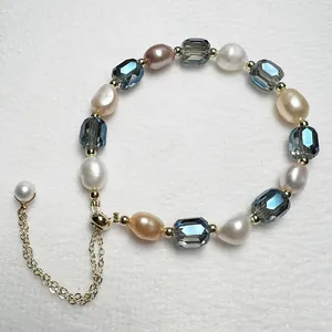Detailed macro view of baroque pearls and blue faceted crystals with gold-tone pull chain