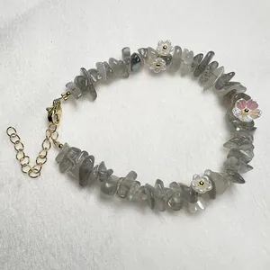 Detail of natural grey labradorite stone bracelet with white acrylic flower charms