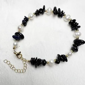 Detail van de blauwe zandsteen en zoetwaterparel armband met gouden karabijnsluiting