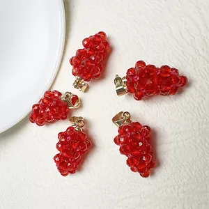 Lot de cinq pendentifs raisin en spinelle rouge avec anneaux dorés sur cuir blanc