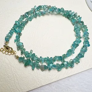 Gros plan d'un collier en pierres naturelles péridot apatite avec fermoir mousqueton doré