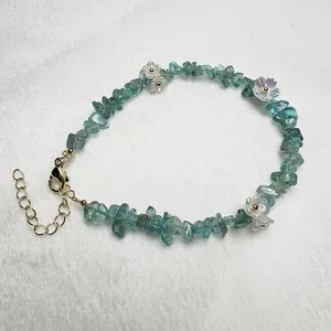 Macro shot of natural aquamarine and garnet beaded bracelet with golden floral details