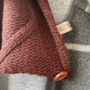 Gros plan de la maille en pure laine avec bouton en résine et étiquette de matière
