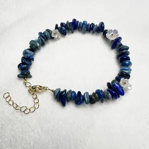 Macro detail of natural blue stone beads and small white flower accents on bracelet