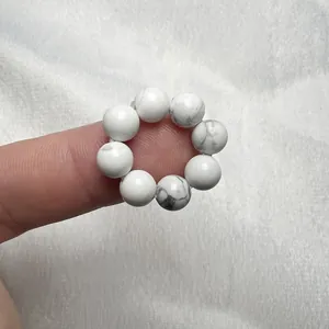 Dettaglio dell'anello elastico con perline di turchese bianco e trama marmorea