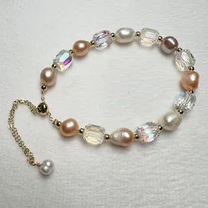 Close-up of baroque pearls and iridescent beads with an adjustable gold slider clasp