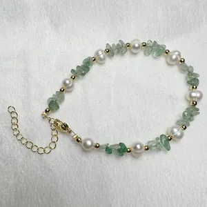 Detail van natuurlijke zoetwaterparel armband met groene aventurijn stenen en gouden sluiting