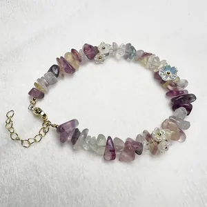 Macro view of crystal beaded bracelet with amethyst gravel and floral charms