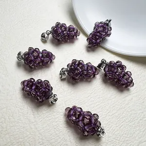 Gros plan détaillé de six pendentifs de raisin violets avec fermoirs en argent sur fond blanc