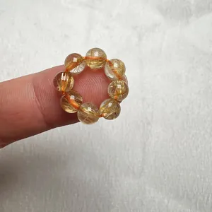 Macro di anello in perle di quarzo rutilato oro che mostra gli aghi interni dorati