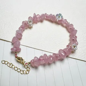 Detailed macro view of pink crystal beaded bracelet with small white flower charms