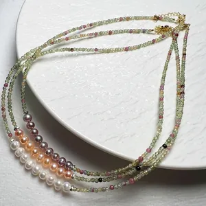 Détail de colliers en perles de tourmaline colorées et perles d'eau douce avec fermoir doré