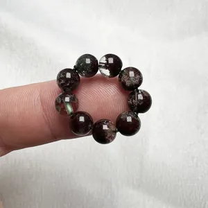 Dettaglio dell'anello di perle in cristallo di quarzo rosso naturale indossato sul dito