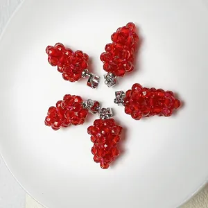 Détail macro de pendentifs raisins en spinelle rouge facetté avec fermoirs argentés