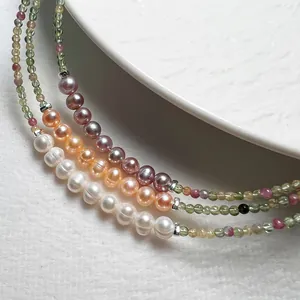 Gros plan de perles de tourmaline colorées et perles d'eau douce sur colliers élégants
