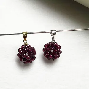 Vue détaillée de pendentifs sphériques en grenat avec bélières en or et en argent