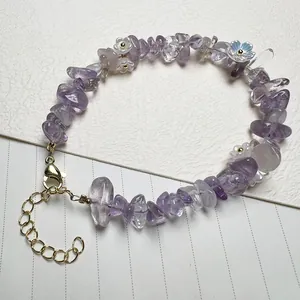 Detailed close-up of amethyst chips and floral charms on a beaded quartz bracelet