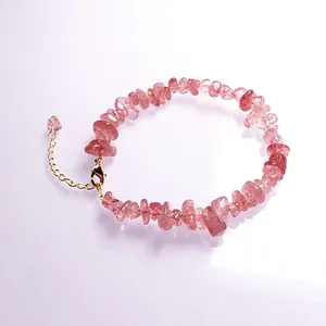Macro shot of natural pink strawberry quartz bracelet with gold lobster clasp and chain