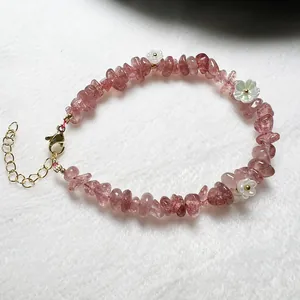Detail of pink strawberry crystal beaded bracelet with white flowers and gold clasp