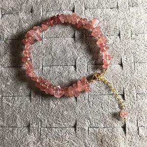 Macro detail of natural strawberry quartz chip bracelet with gold adjustable lobster clasp