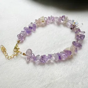 Detail of natural purple amethyst chips bracelet with white flower beads and gold clasp