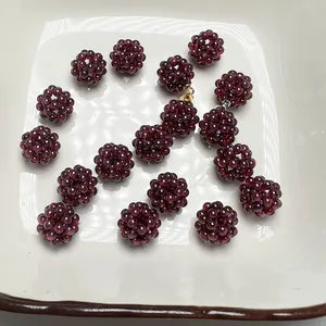 Gros plan de pendentifs sphériques en grenat faits main avec tissage et fermoir métallique