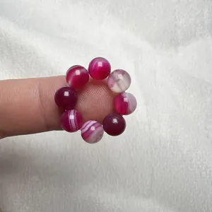 Dettaglio di un anello in agata naturale con sfere di pietre preziose rosa e bianco strutturato