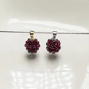 Détail de pendentifs sphériques en grenat tissé avec fermoirs en or et en argent