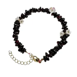 Natural garnet bracelet featuring pearl-white flower charms and golden lobster clasp