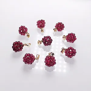 Vue détaillée de pendentifs en forme de boules de grenat avec attaches en métal doré