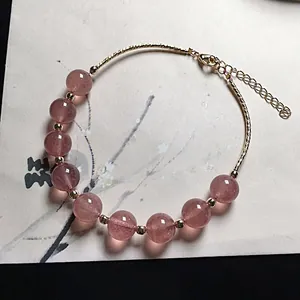 Macro detail of strawberry quartz bead bracelet with adjustable 14K gold-plated clasp