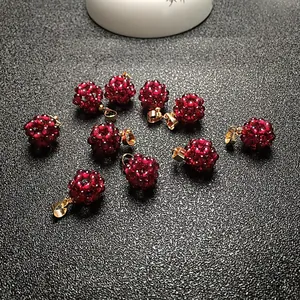 Gros plan d'un pendentif en perles de grenat rouge foncé à facettes et fermoir doré