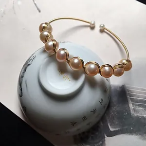 Detail of 14K gold wire wrapped bangle featuring lustrous freshwater pink pearls