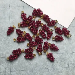 Close-up of cluster garnet grape pendants with gold-filled clasps on textured background