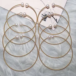 Handcrafted 14K gold wire wrapped freshwater pearl open bangles on soft white fur background