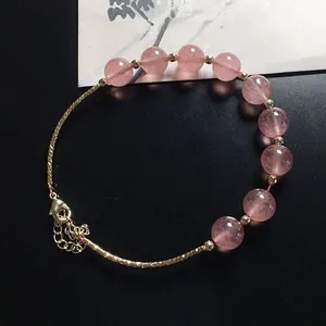 Detail of pink strawberry quartz beads with 14K gold-plated adjustable chain bracelet