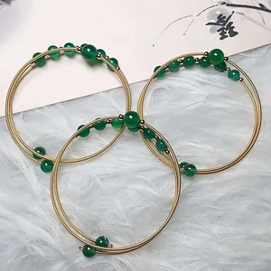 Detailed view of 14K gold-wrapped wire bracelet set with green agate beads
