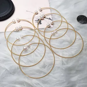 Detailed view of 14K gold-filled wire rings featuring freshwater pearls on soft plush