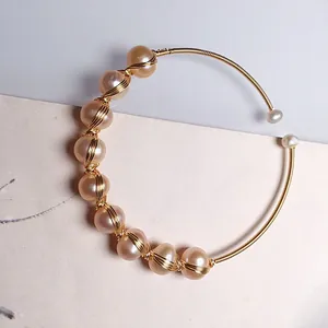 Elegant 14K gold wire wrapped bracelet featuring champagne freshwater pearls and white beads