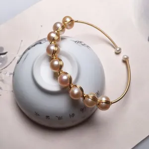 Detailed view of handmade 14K gold wire wrapped bracelet with pale pink freshwater pearls