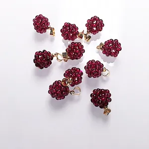 Pendentif boule en perles grenat avec fermoir en métal doré sur fond blanc pur