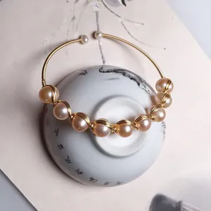 Detailed view of handmade pink freshwater pearl open cuff with 14K gold wire wrapping