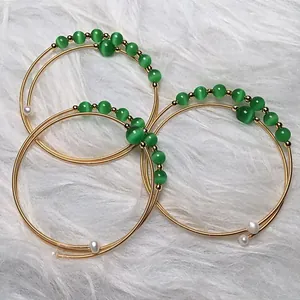 Detail of 14K gold filled multi-layer wire wrap bracelet with green cat eye beads and pearls
