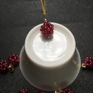 Vue détaillée du pendentif en perles de grenat rouge fait main sur chaîne dorée fine