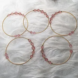 Detail of 14K gold-filled wire wrap bracelets with pink strawberry quartz beads