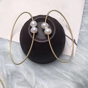 Macro view of gold wire wrapped freshwater pearl bracelet with flexible spring texture