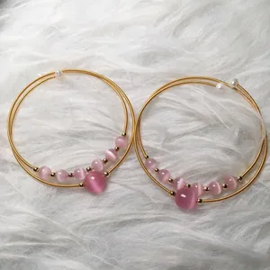 Detail of pink cat-eye stone beads and white pearls on 14K gold-filled wire bracelets