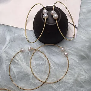 Close-up of minimalist 14K gold-filled wire earrings with white freshwater pearls